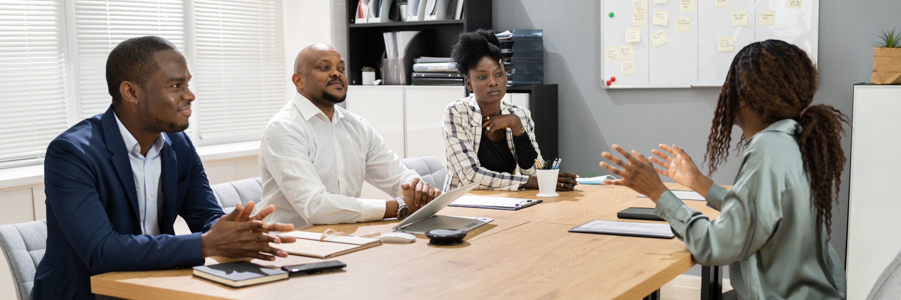 A group of 4 colleagues in a meeting.